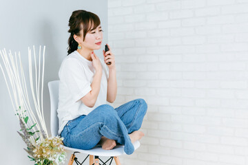 椅子に座りながらネックケアするアジア人女性（首）
