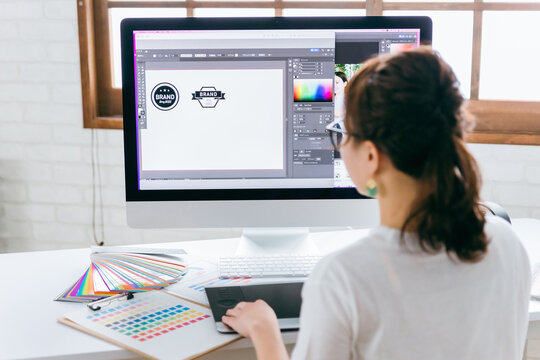 ペンタブでロゴデザインの仕事をするグラフィックデザイナー・イラストレーターの女性
