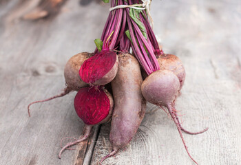 a bunch of red table beets on a wooden table