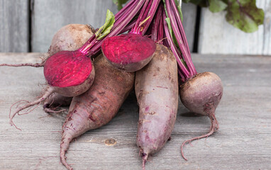 a bunch of red table beets on a wooden background close-up