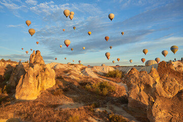 Hot air balloons flying in sunset sky Cappadocia, Goreme, Turkey. Great tourist attraction - sunrise balloning over Cappadocia valleys