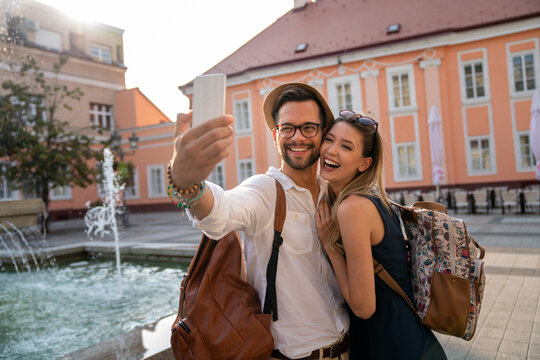 Happy traveling couple taking selfie, having fun on vacation. People technology happiness concept.