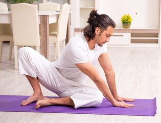 Young man doing physical exercises at home