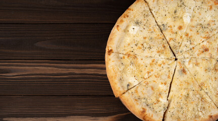 Delicious pizza Four Cheeses with cheddar, Parmesan, mozzarella and tomato sauce. on wooden background. View from above.