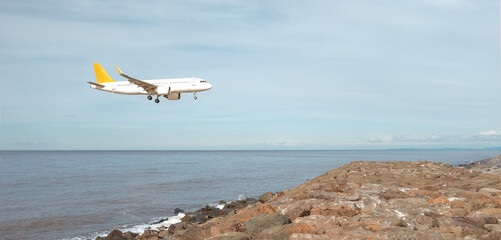 Airplane in the sky.Tourist plane is landing over the sea