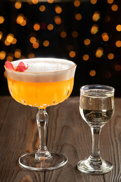 Cocktail on a wood background. Cold citrus alcoholic drink with Aperol, passion fruit syrup and proseco served with vodka