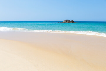 Tropical beach background, clean sandy beach with blue sea background, summer outdoor day light