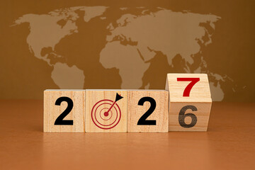 Countdown and business planning in 2027. Wooden cubes with the letters 2027 on a table with the world map background - obrazy, fototapety, plakaty