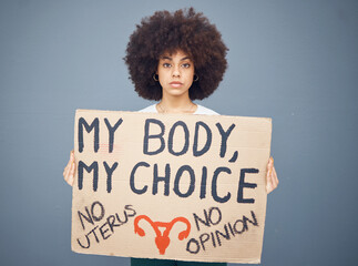 Black woman afro, protest and poster for abortion, female choice or decision against a studio...
