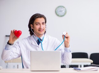 Young handsome doctor cardiologist working in the clinic