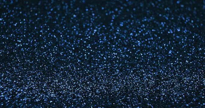 Bokeh light background. Blur glitter texture. Defocused blue color shiny sparkles glow reflection on dark black abstract free space. Shot on RED Cinema Camera.
