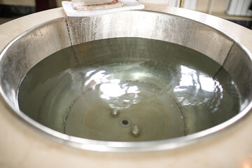 The font in the church. The baptism of a child.