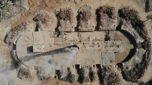 Aerial shot of burning of stubble at a farm in Khairpur Sindh with dates palm tree lying in the floor.