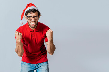 Man with beard and christmas hat angry looking at camera isolated. Furious christmas man looking at...