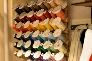 Coils of multicolored threads in the tailor's workshop.Small business.Hobby and handmade concept.Selective focus, close-up.