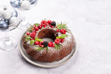 Christmas cake with pomegranate seeds, cranberries and rosemary