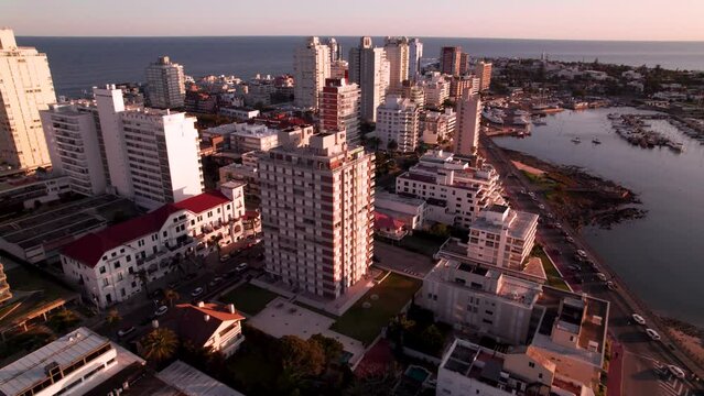 Aerial move around building in the city in Punta Del Este, Uruguay on sunset. High quality 4k drone footage