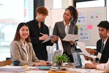 Shot of smiling young businesswoman attending morning meeting at bright modern corporate office