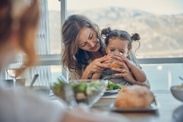 Mother, baby at lunch and drinking juice with family at dining room patio table, by the sea and on...