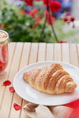Aesthetic french croissant on the plate on the garden terrace. Copy space.