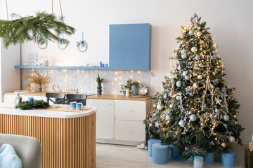 Interior light grey kitchen and red christmas decor. Preparing lunch at home on the kitchen concept. Focus on tree