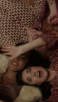 Three women lying on the floor dancing and playing with the balloons