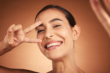 Face, peace sign and woman happiness selfie of a model with a funny hand sign. Portrait of a comic hand gesture and beauty laughing, feeling silly and happy about youth with smile and beautiful skin