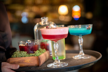 glasses alcohol cocktail set on a waiter tray in bar