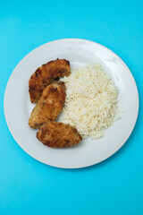 Delicious crispy fried breaded chicken breast strips with boiled rice