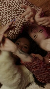 Three women lying on the floor dancing and playing with the balloons