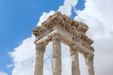 Obraz premium The Temple of Trajan in Pergamon Ancient City. Close up fragment of the entablature of the ruined temple with a stone-cut relief on the frieze. History, art or architecture concept. Bergama, Turkey