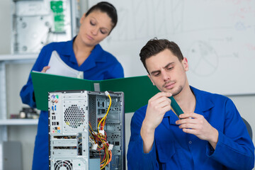 team of students examining and repairing computer parts
