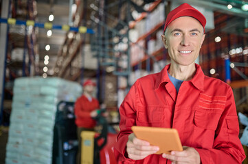 Storehouse supervisor and a lift truck operator on the background