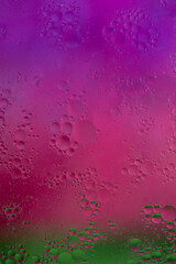 Watercolor transition of purple to fuchsia and green background for oil drops