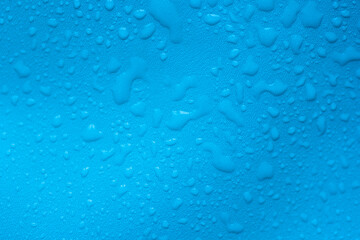 Water drops on a blue leather surface as an abstract background
