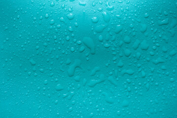 Water drops on a turquoise leather surface as an abstract background