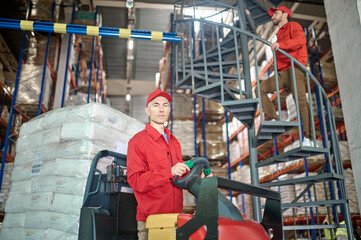 Forklift operator and his coworker in the storehouse