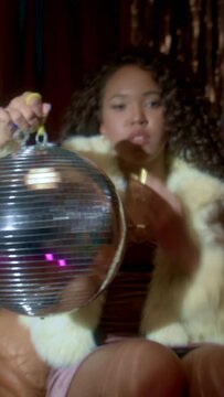 Black woman spinning a disco ball
