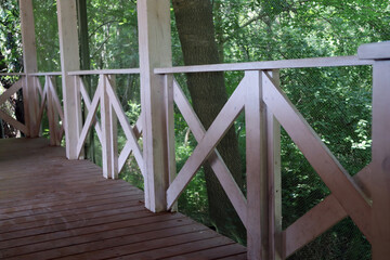 White wooden terrace. Railing. House in the green forest