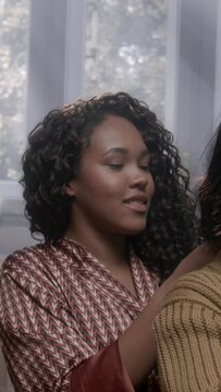 Three women braiding each other's hair