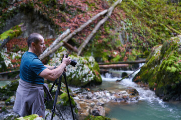 Photographer shooting landscapes in a gorge with a river