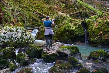 Photographer shooting landscapes in a gorge with a river