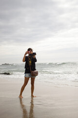 girl taking photos on a beach in Portugal