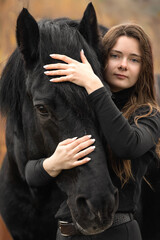 Portrait of beautiful girl with black stallion