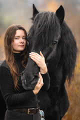 Portrait of beautiful girl with black stallion