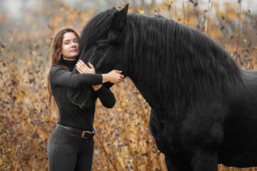 Portrait of beautiful girl with black stallion