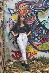 Fille écoutant de la musique devant un graffiti