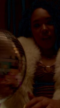 Black woman holding a disco ball