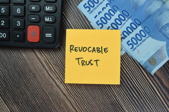 Concept of Revocable Trust write on sticky notes isolated on Wooden Table.