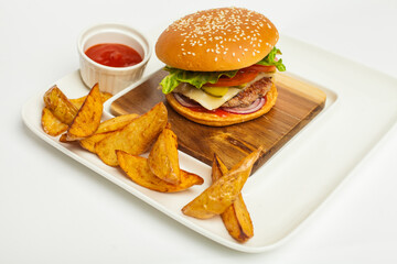 Closeup of fresh delicious burger with  French fries on wooden plate on white background